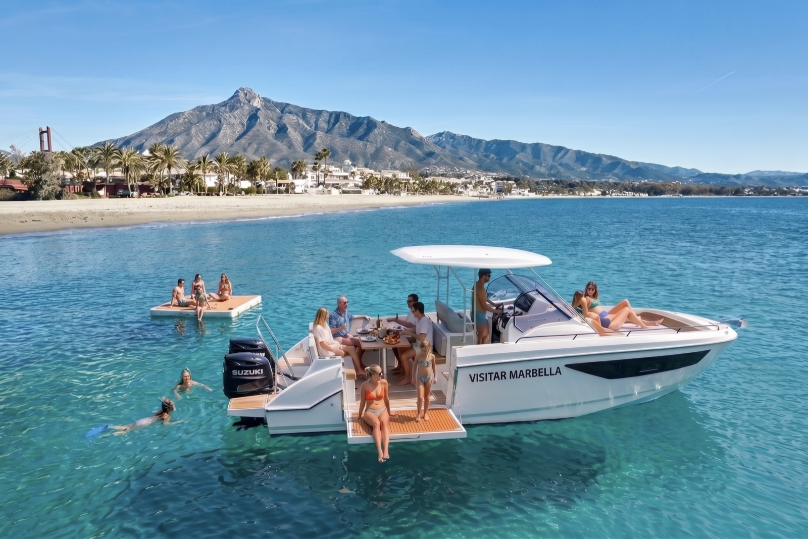 Guests swimming beside the Visitar Marbella boat anchored below La Concha